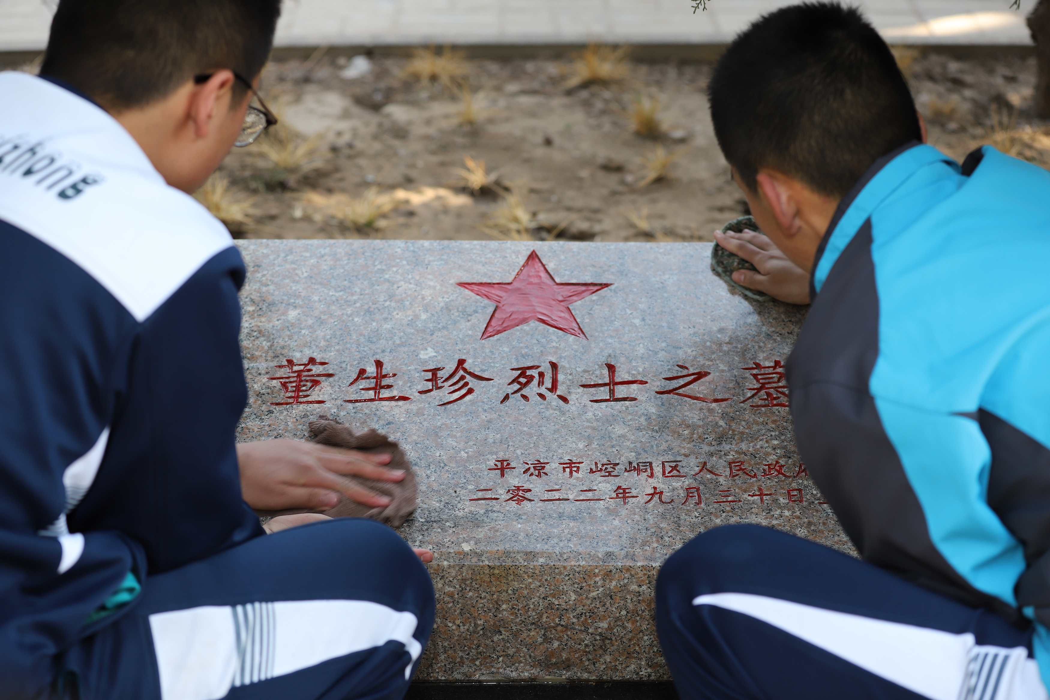 08——3月29日，甘肅省平?jīng)鍪械谒闹袑W(xué)學(xué)生在平?jīng)鍪辛沂苛陥@擦拭烈士墓碑。.JPG