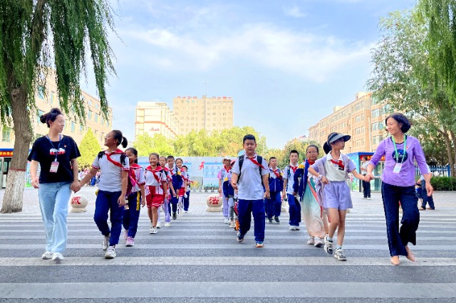 01 臨澤縣城關小學“紅燭先鋒”護學崗教師護送學生放學。謝靜 攝.jpg