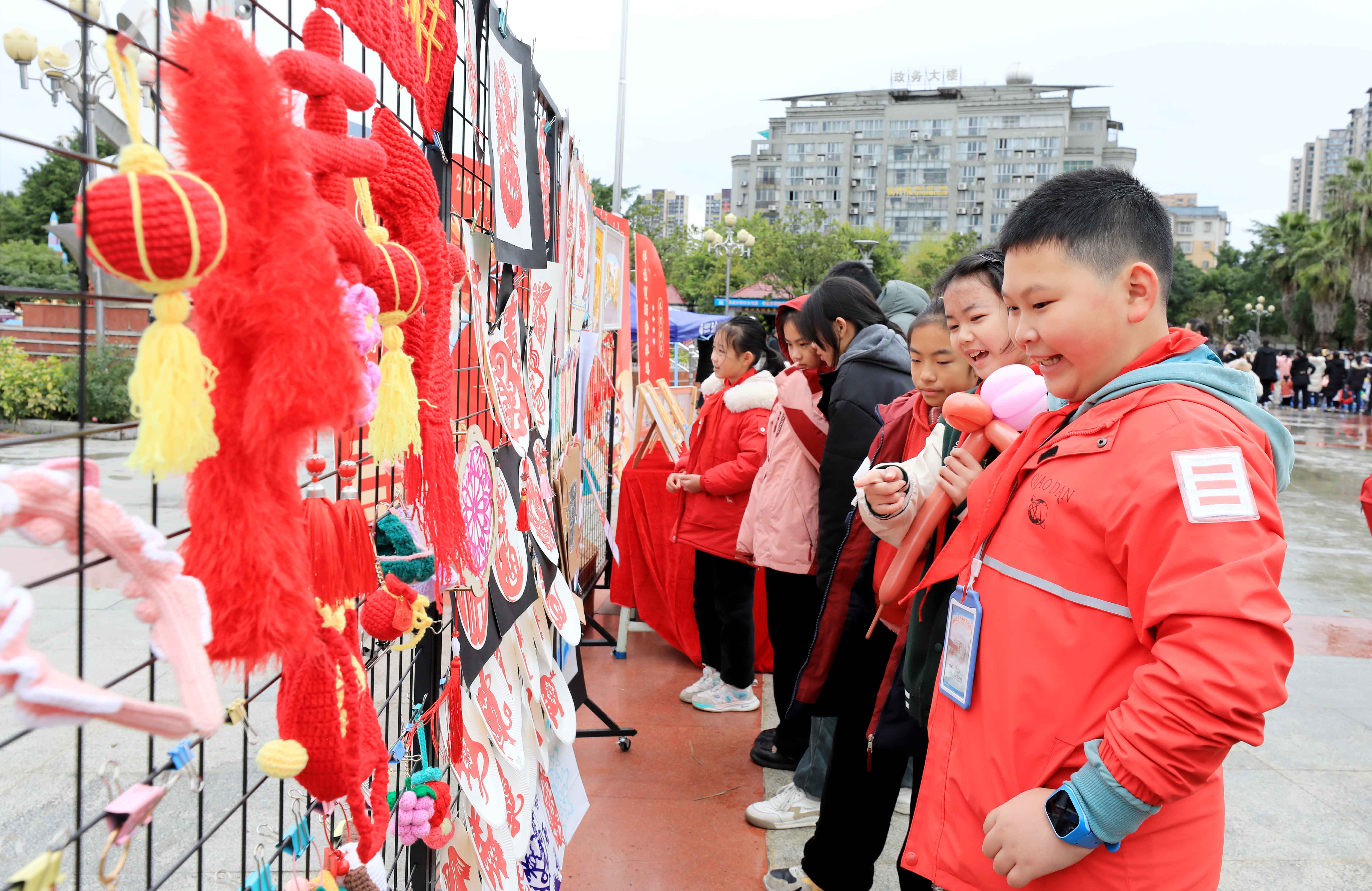圖7：1月20日，在廣西柳州市融安縣長(zhǎng)安廣場(chǎng)，學(xué)生在非遺集市上選購作品。（譚凱興 攝）.JPG