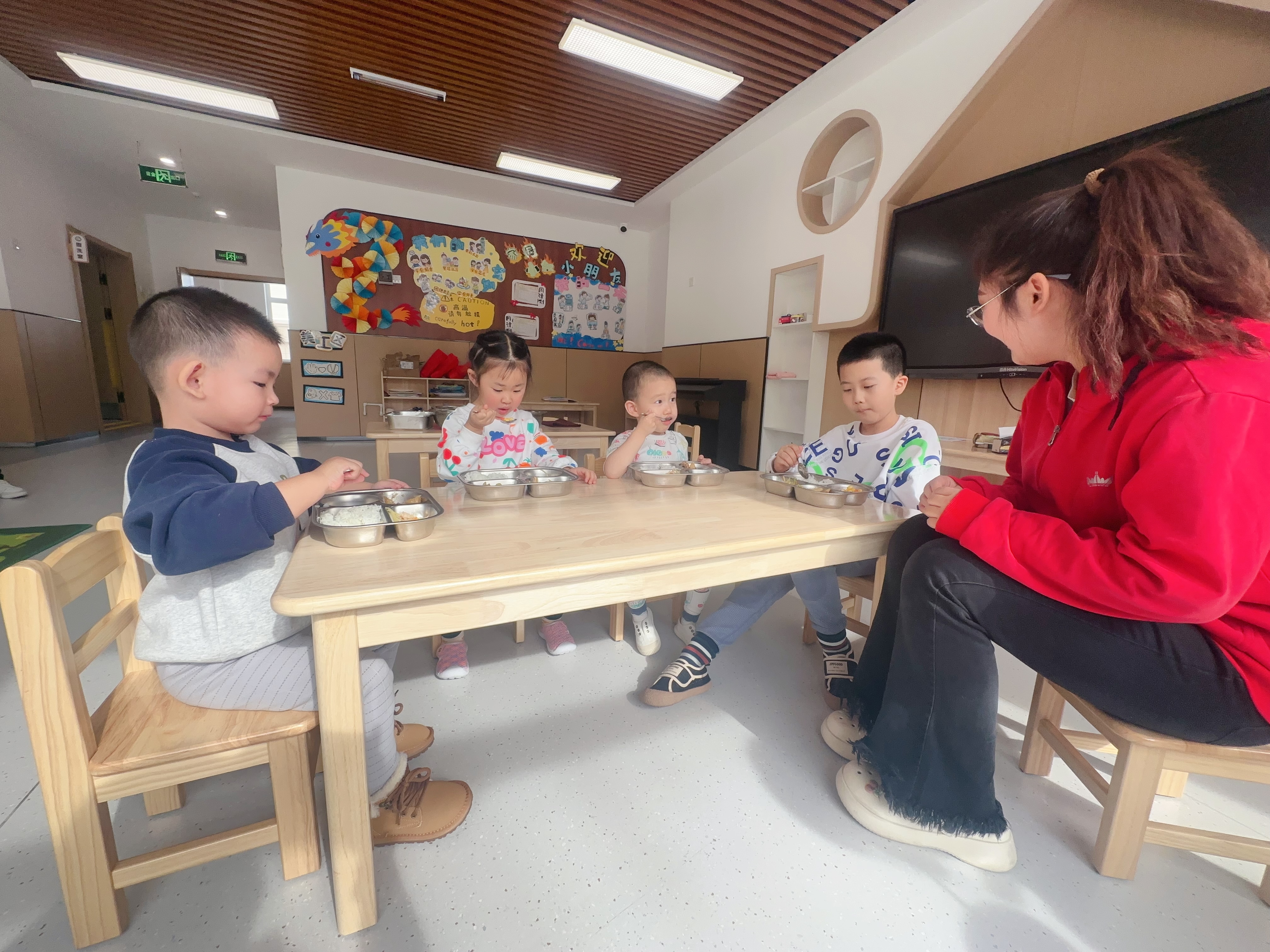 綠園區(qū)第四實(shí)驗(yàn)幼兒園，孩子在開(kāi)心地吃著園區(qū)精心搭配的營(yíng)養(yǎng)午餐（綠園區(qū)教育局供圖）.jpg