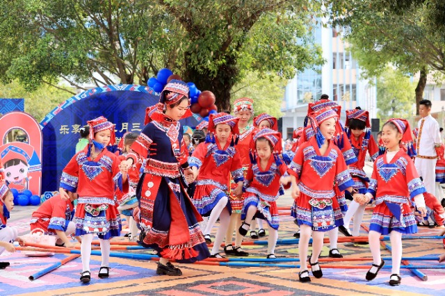 圖4：4月9日，在廣西柳州市融安縣實(shí)驗(yàn)小學(xué)校園，一名老師帶著學(xué)生跳竹竿舞。（譚凱興 攝）.JPG