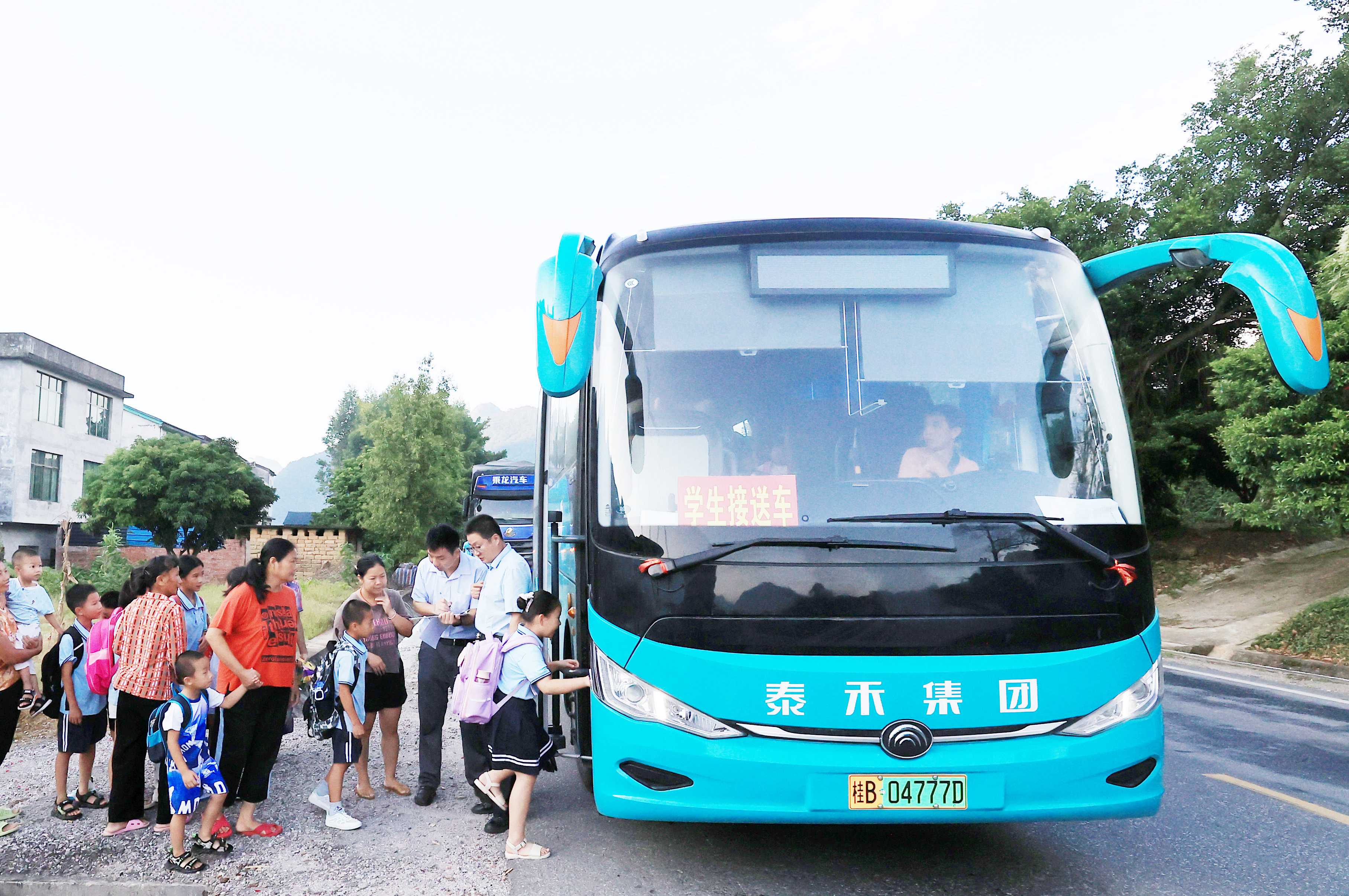 圖2：9月2日早晨，在廣西柳州市融安縣浮石鎮(zhèn)諫村村，工作人員在核對(duì)乘車人員名單，準(zhǔn)備送學(xué)生去學(xué)校讀書。（譚凱興 攝）.JPG