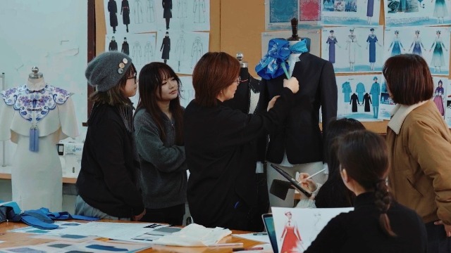 東華大學服裝與藝術設計學院師生團隊在討論結構細節(jié)。學校供圖